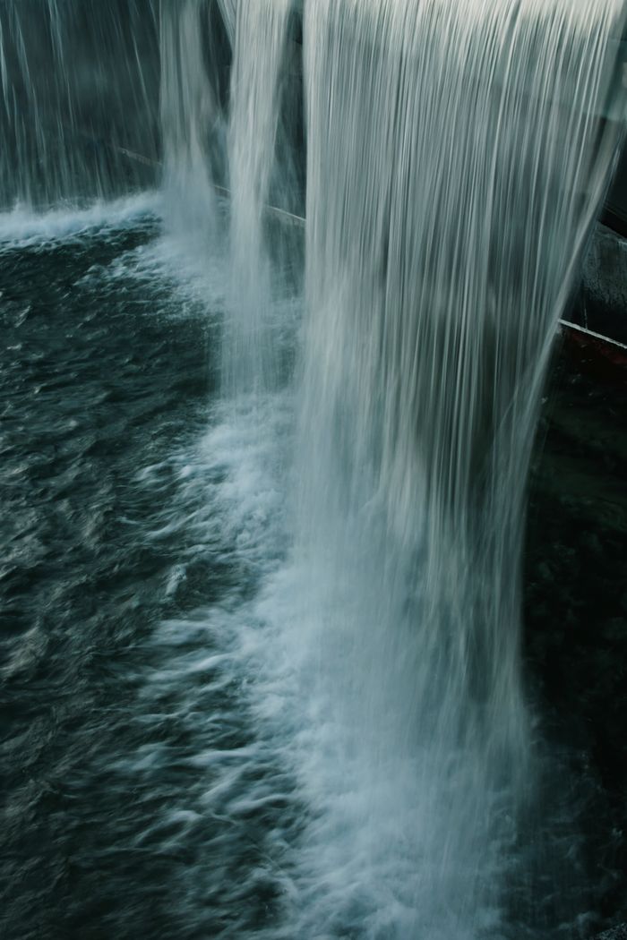 A serene waterfall cascading vertically, showcasing the purity and motion of flowing water in nature.
